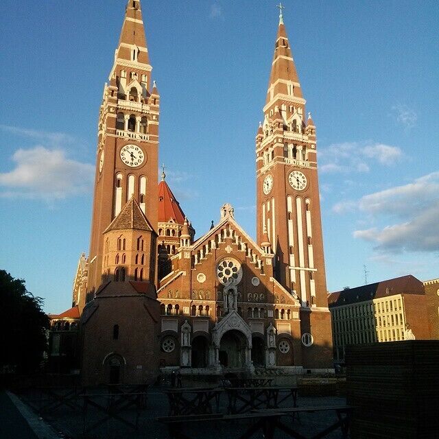 A historic church with two tall towers and a central clock tower.
