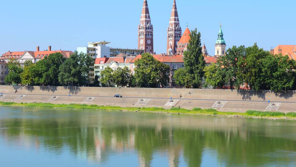 A river with a bridge and two prominent towers in the background.