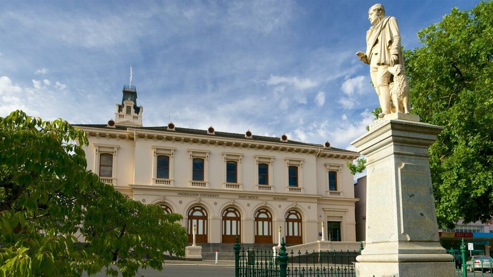Un edificio histórico con una estatua en primer plano.