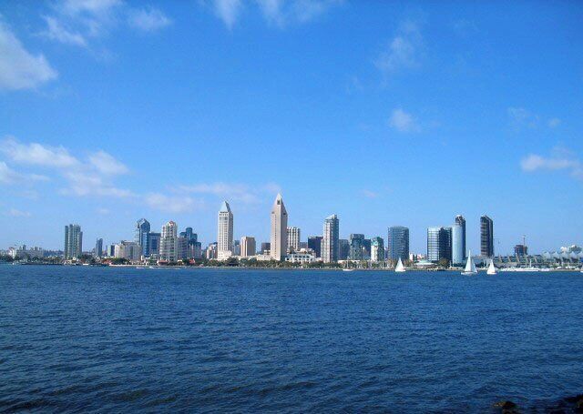 Un horizonte urbano con edificios altos y una masa de agua al frente.