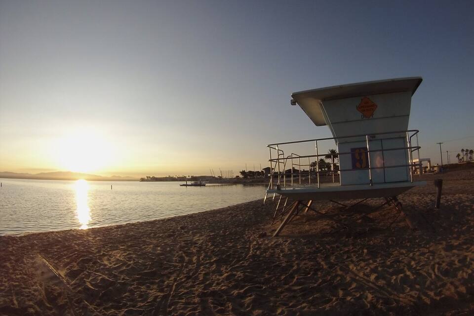 Una torre de salvavidas en una playa al atardecer.