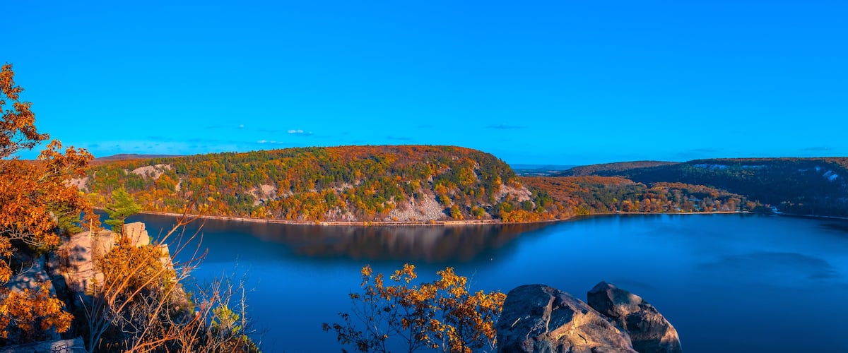 A lake surrounded by autumn-colored trees and rocky terrain.