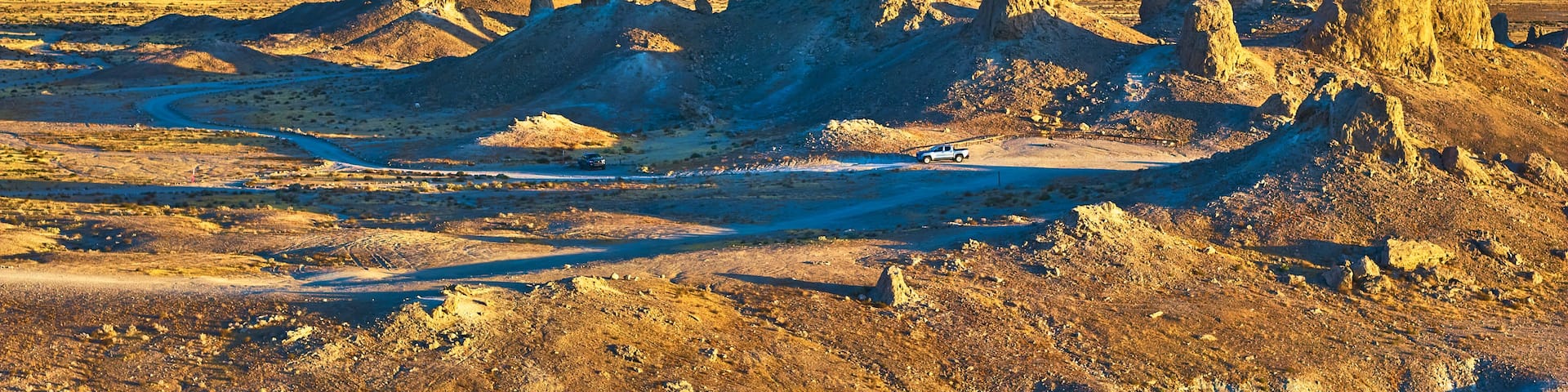 A desert landscape with prominent rock formations and a clear blue sky.