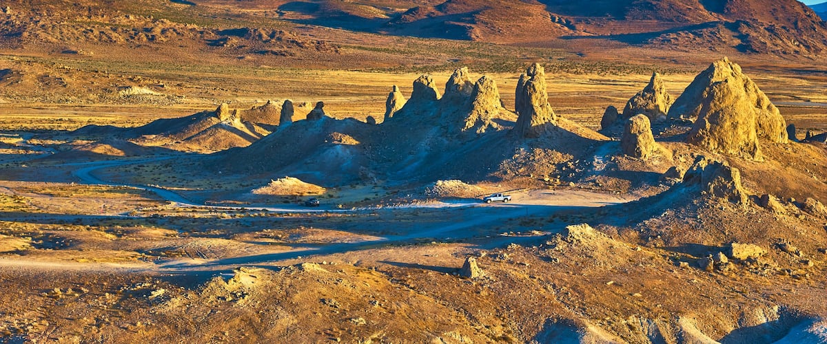 A desert landscape with prominent rock formations and a clear blue sky.