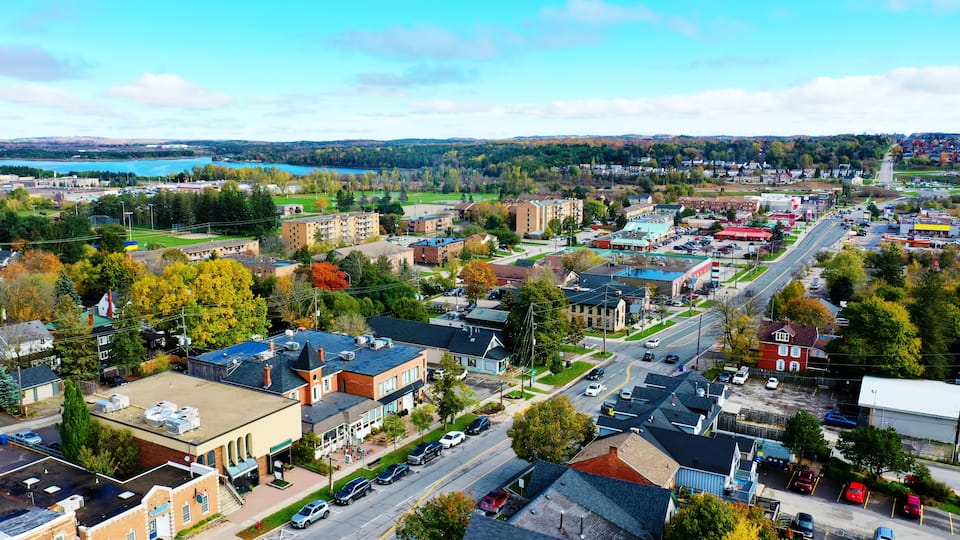 A town with a river, buildings, and a parking lot.