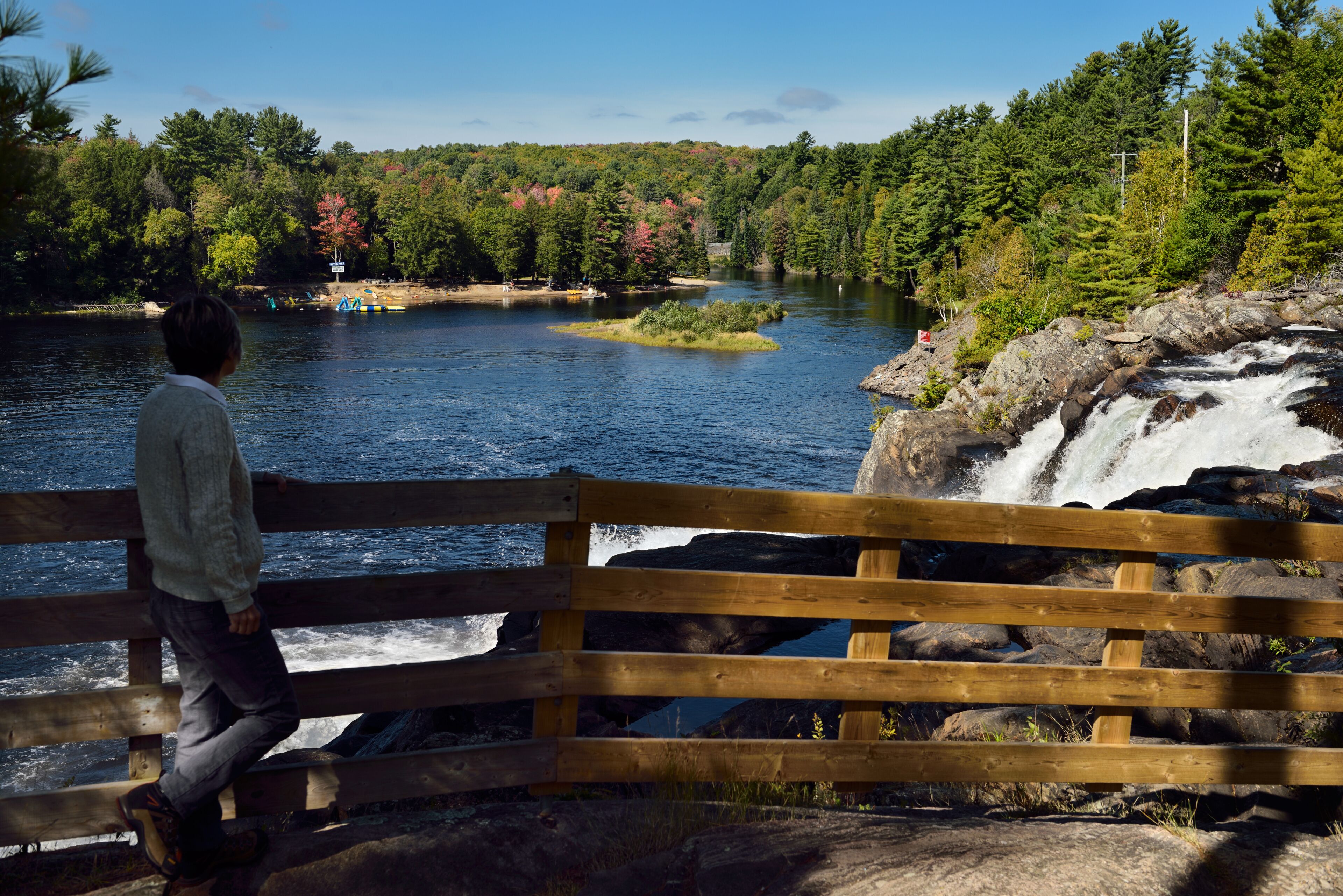 Retired woman hiker viewing North Muskoka river at High Falls Bracebridge Ontario