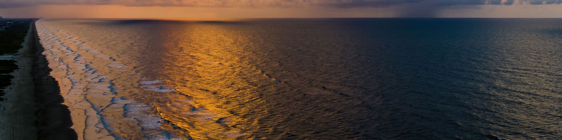 An aerial stormy beach sunrise with beautiful colors.