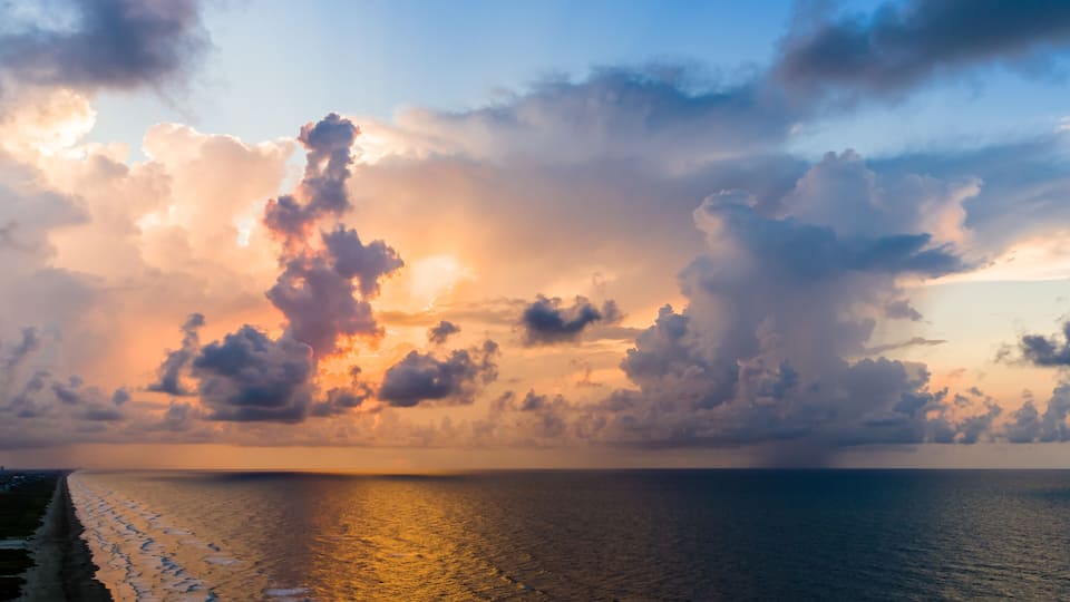 An aerial stormy beach sunrise with beautiful colors.