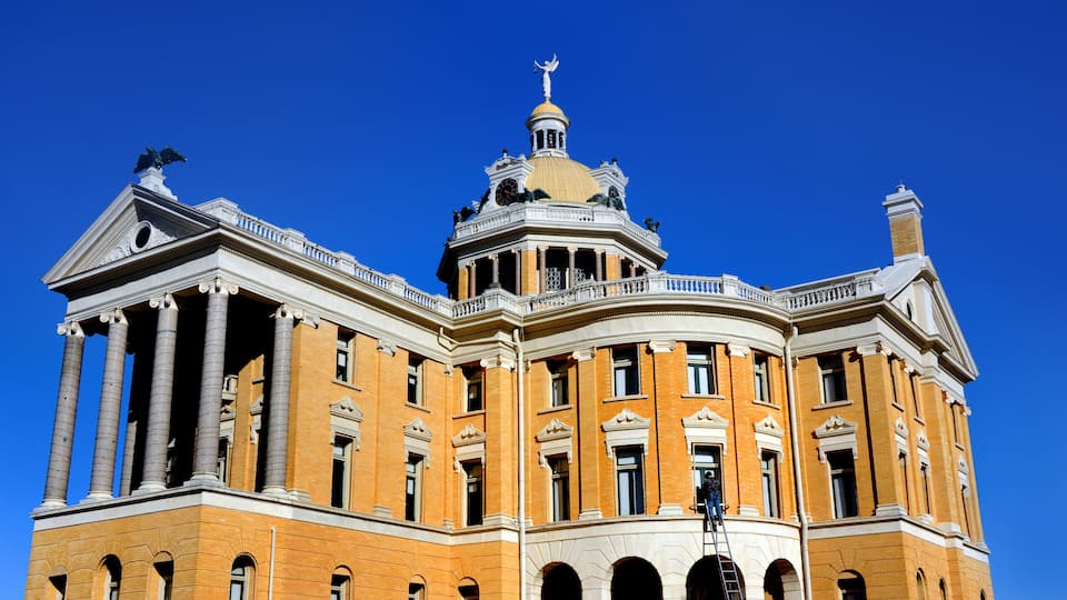 A large, ornate building with a golden dome and statues on top.