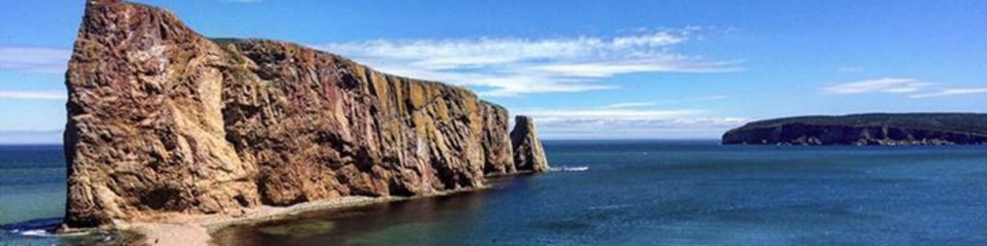 A coastal cliff with a clear view of the ocean.