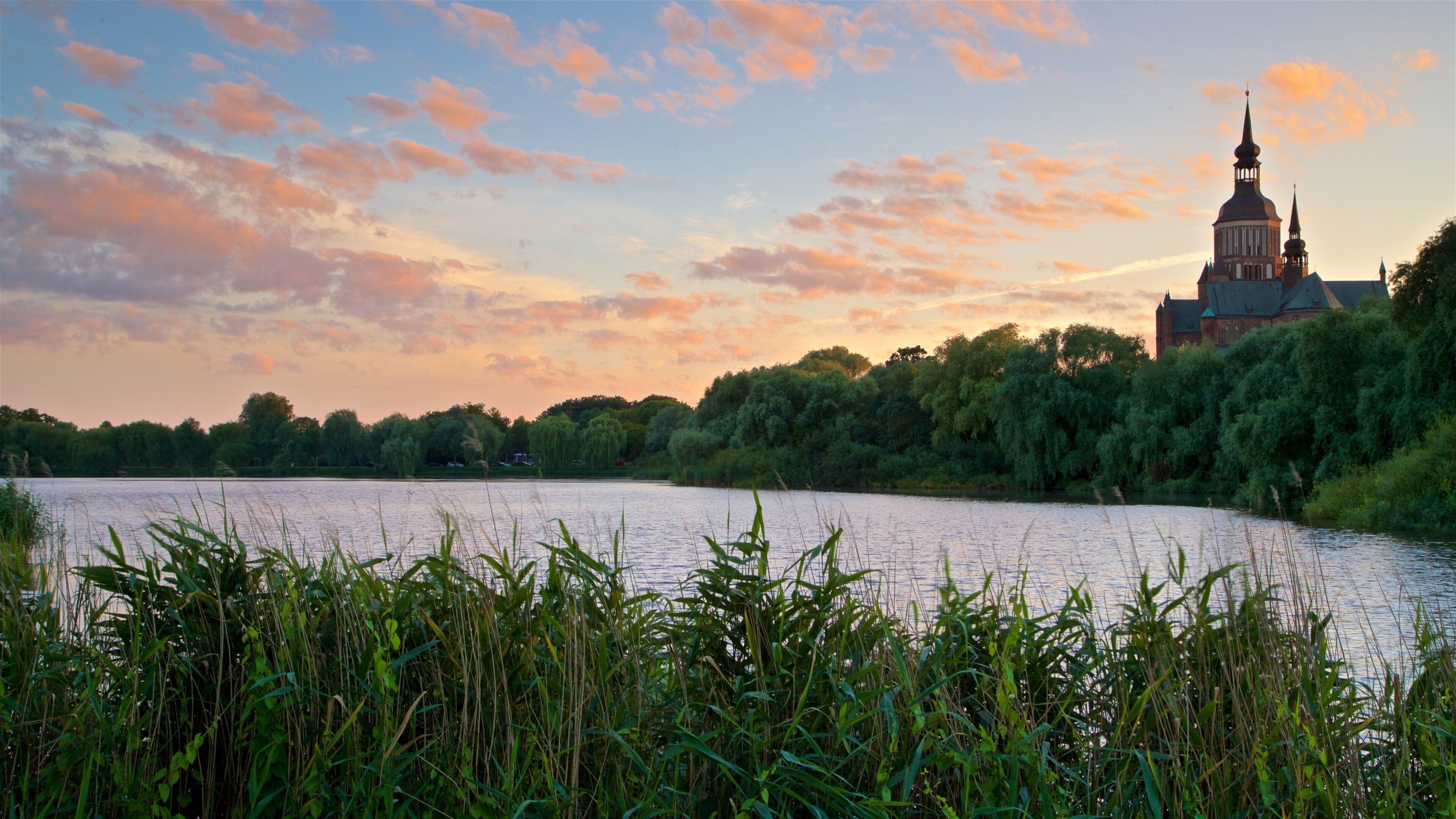 Stralsund som viser en sø eller et vandhul, en solnedgang og historiske bygningsværker