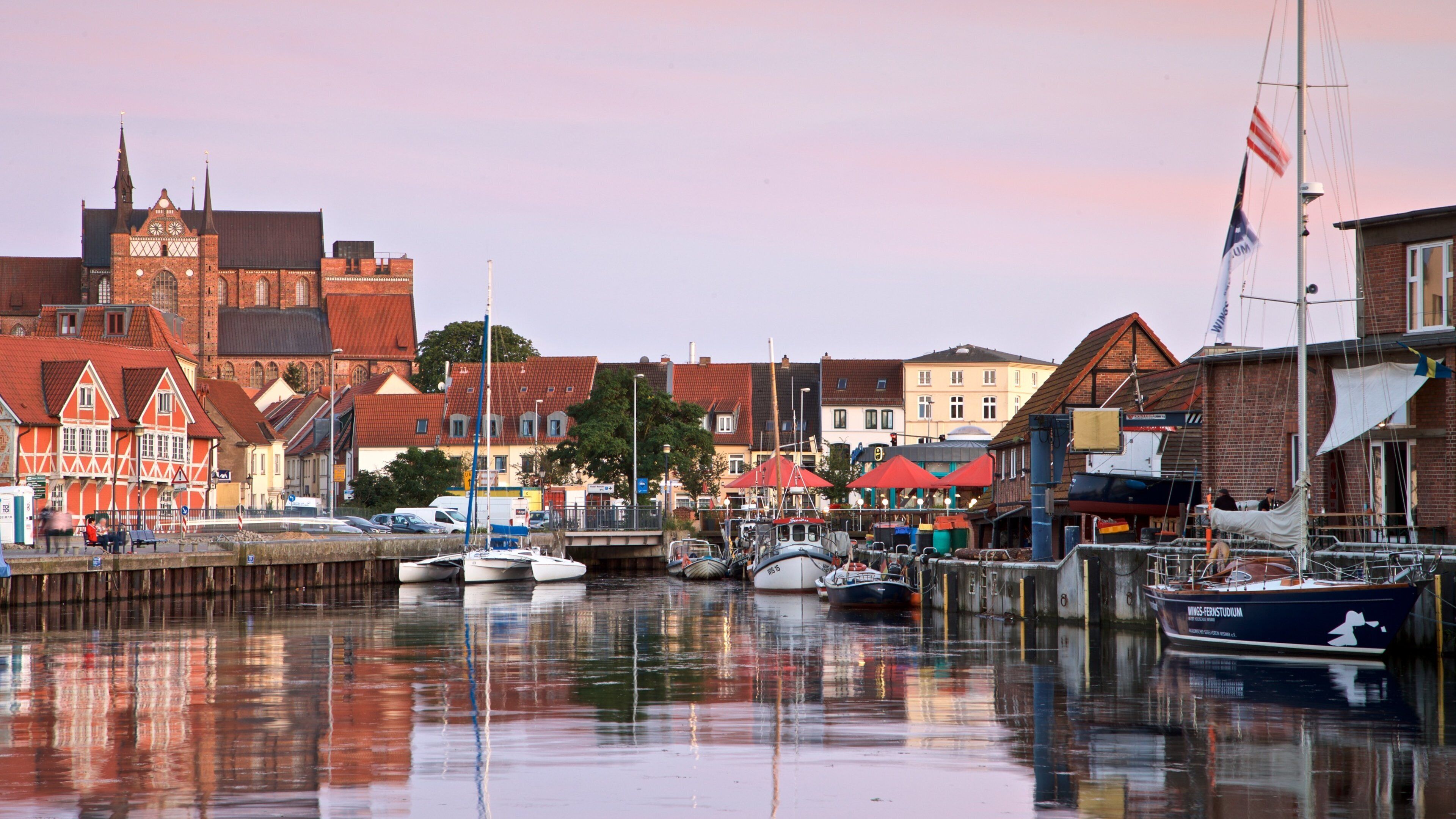 A harbor with boats, a church, and traditional buildings.