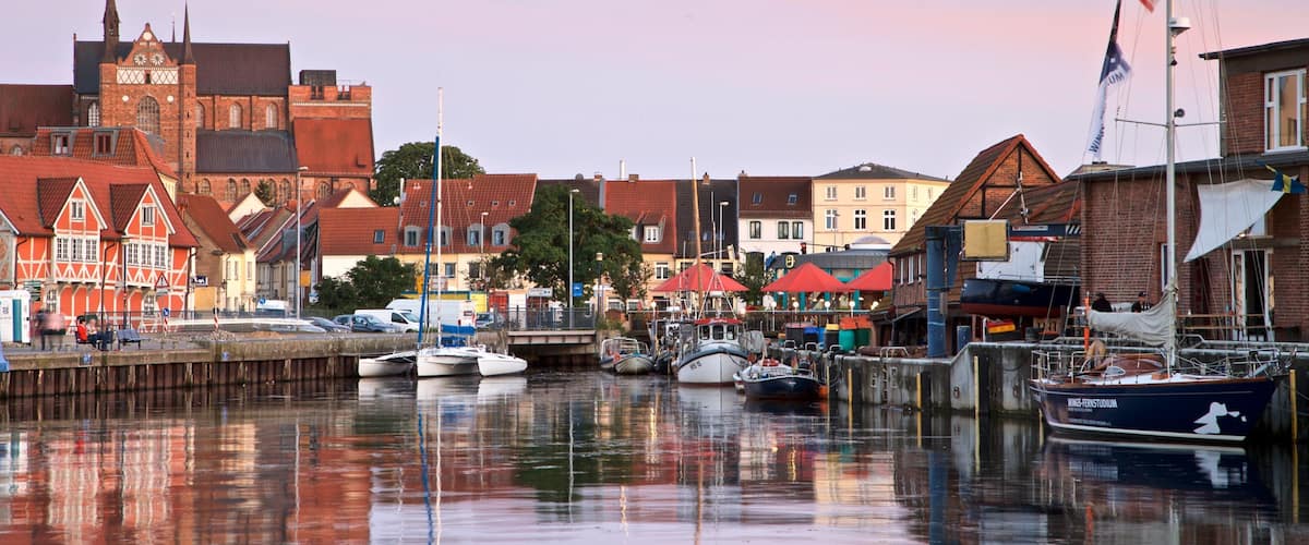 A harbor with boats, a church, and traditional buildings.