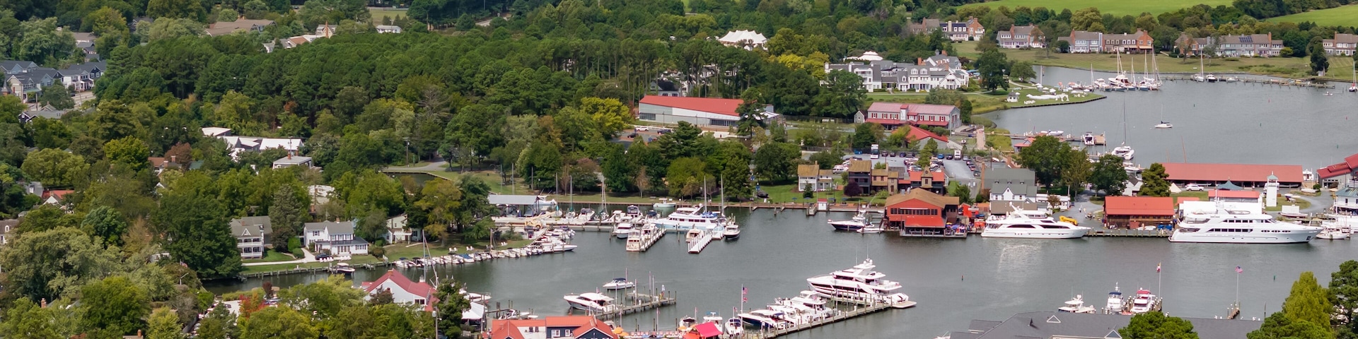 Une ville côtière dotée d’un port de plaisance, de maisons et d’un paysage boisé.