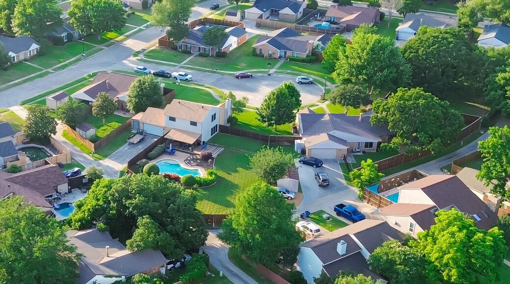 Panorama aerial view residential street in lush greenery neighborhood in Coppell Texas Dallas Fort Worth metroplex, row of detached single-family houses swimming pool, large backyard, grassy lawn
