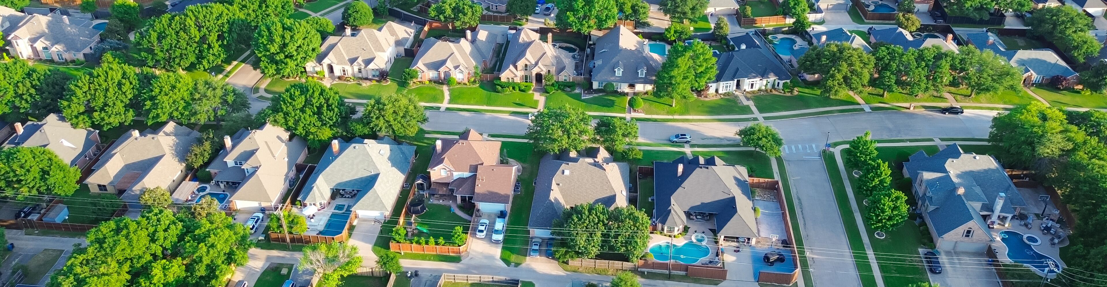Panorama aerial view residential street in lush greenery neighborhood in Coppell Texas Dallas Fort Worth metroplex, row of detached single-family houses swimming pool, large backyard, grassy lawn