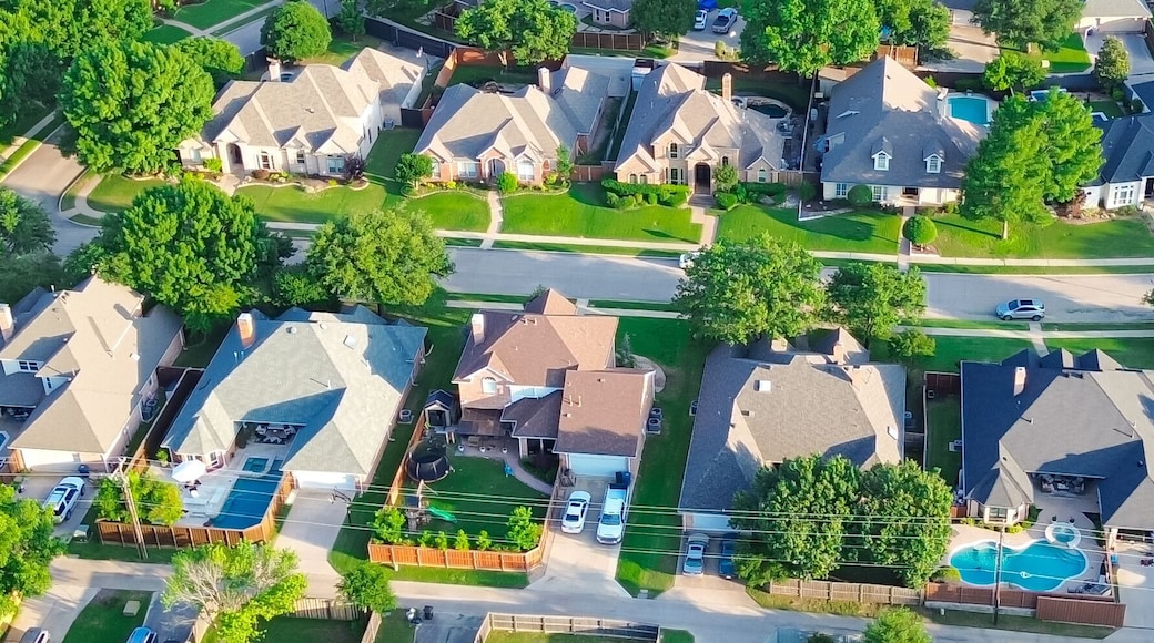 Panorama aerial view residential street in lush greenery neighborhood in Coppell Texas Dallas Fort Worth metroplex, row of detached single-family houses swimming pool, large backyard, grassy lawn