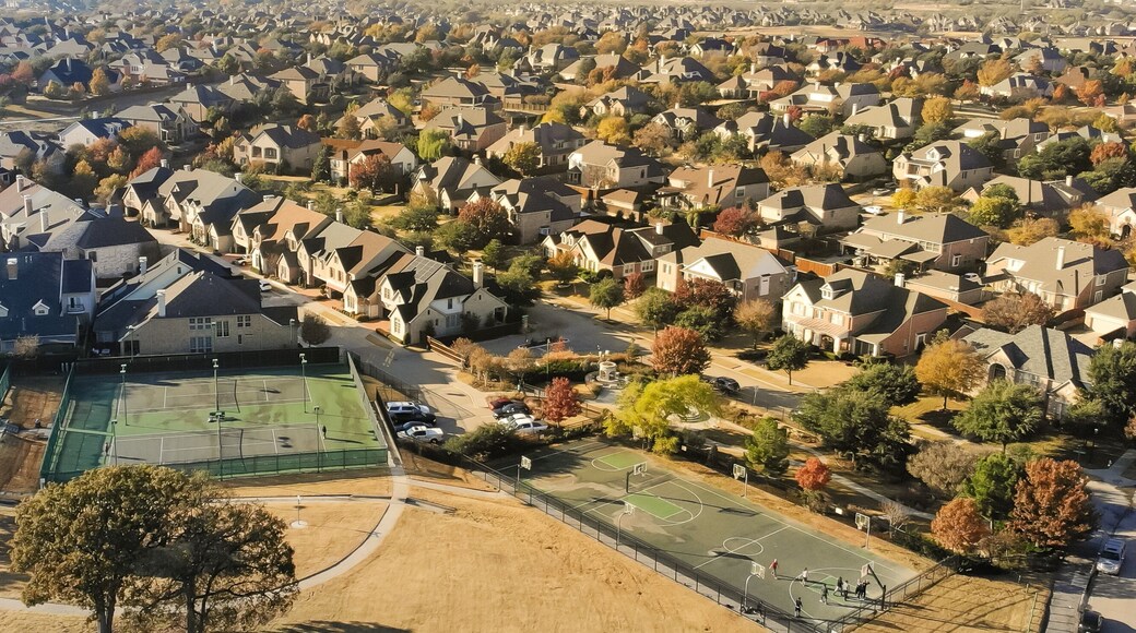 Panorama aerial view large grassy park square near tennis courts complex in residential neighborhood with colorful fall foliage near Dallas, Texas, America