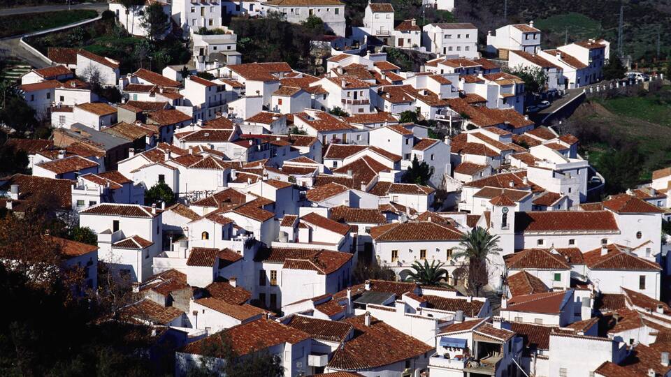 A densely packed village with white buildings and red-tiled roofs.