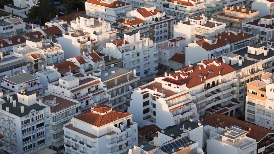 A densely packed urban area with white buildings and red-tiled roofs.