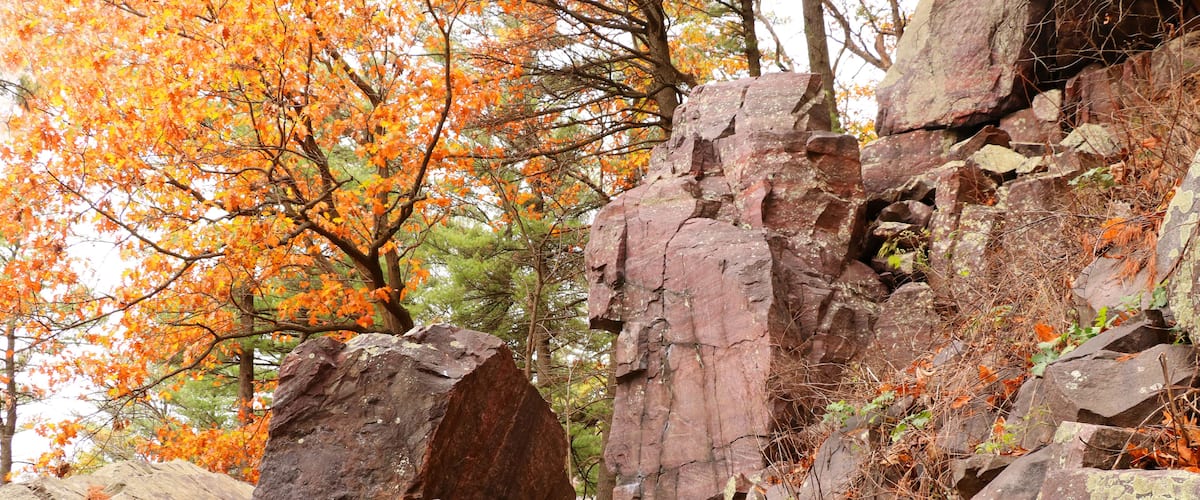 Wisconsin ice age nature background. Autumn view with ice age hiking trail with colorful trees and stone stairs between rocks. Devils Lake State Park, Baraboo area, Wisconsin, USA.