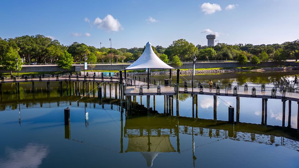 A tranquil lake with a white gazebo and a pier extending into the water.