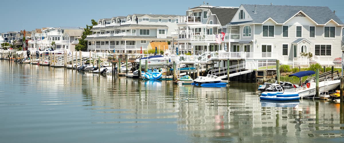 A waterfront with houses and boats docked along the shore.
