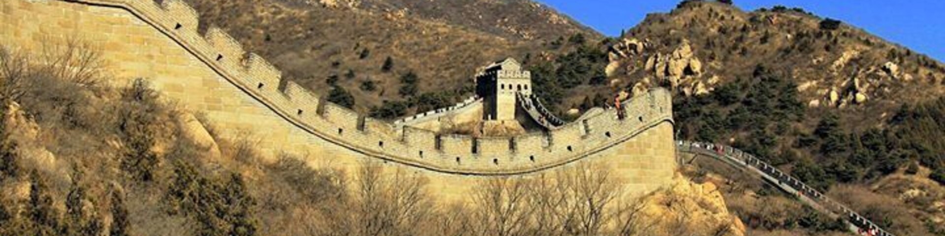 La Gran Muralla China serpenteando a través de un paisaje montañoso.
