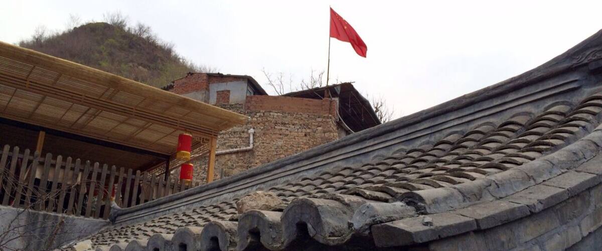 A traditional Chinese roof with a red flag.
