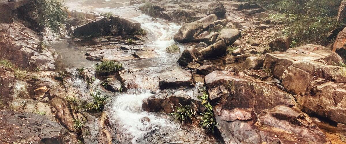 A rocky stream with a wooden bridge.