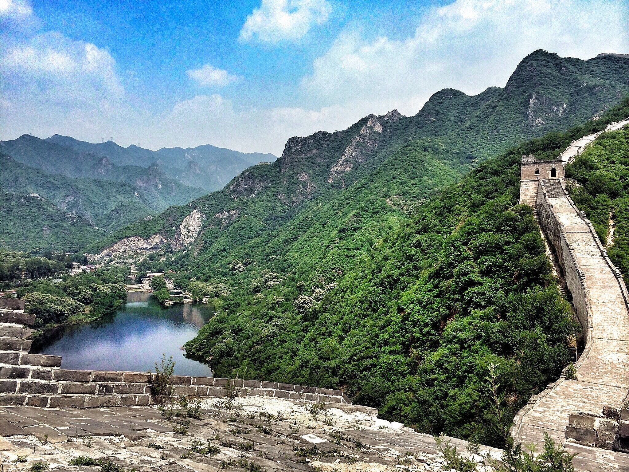 Contrary to the common thought the Great Wall of China is not one long wall, but a series of fortifications with gaps in between. 
This picture was taken at the Huanghuacheng part, where the wall crosses a lake and is only in parts restored.

If you want to enjoy this monument to its full extent without being bothered by Showmen and merchants, get yourself a driver/guide and ask him to drive you to a quiet part of the wall. Huanghuacheng and Jinshanling are perfect spots to enjoy the impressive monument! 
#china #beijing #greatwall #architecture