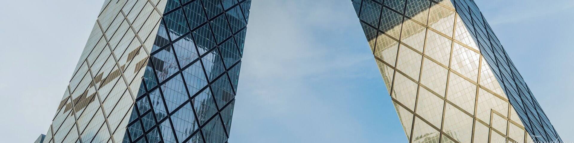 A modern glass skyscraper with a distinctive triangular frame structure.