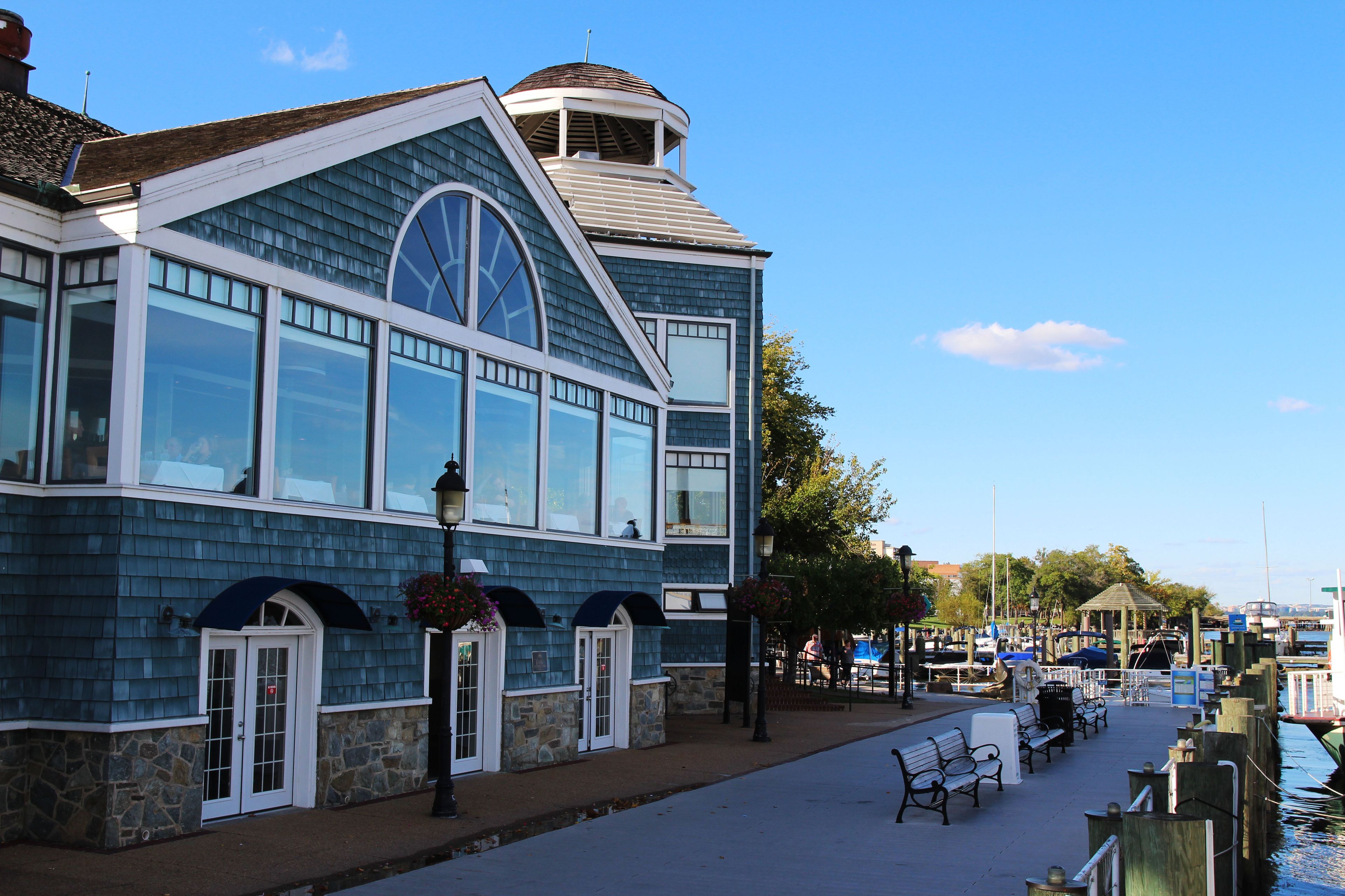 A waterfront building with large windows and a stone foundation.