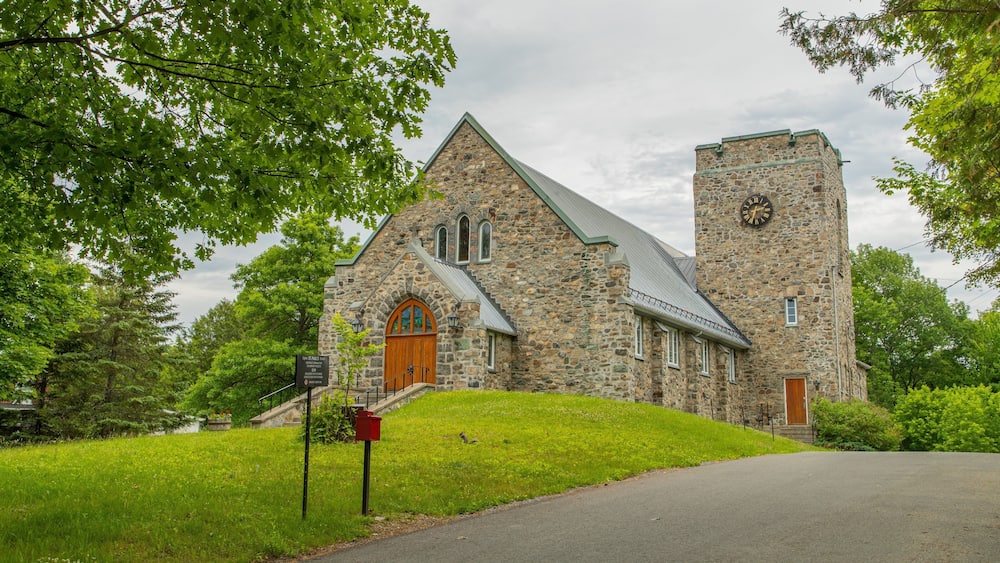 A stone church with a clock tower and a wooden door.