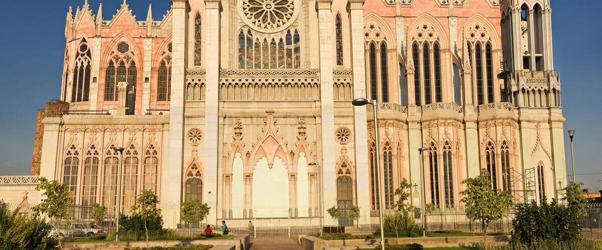 A large, ornate cathedral with intricate Gothic architecture, including pointed arches and a large rose window.