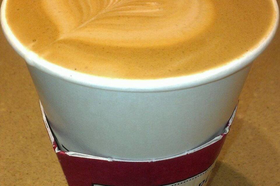 Una tazza di caffè con un disegno decorativo nel latte.
