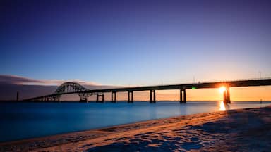 A bridge over calm water at sunset.