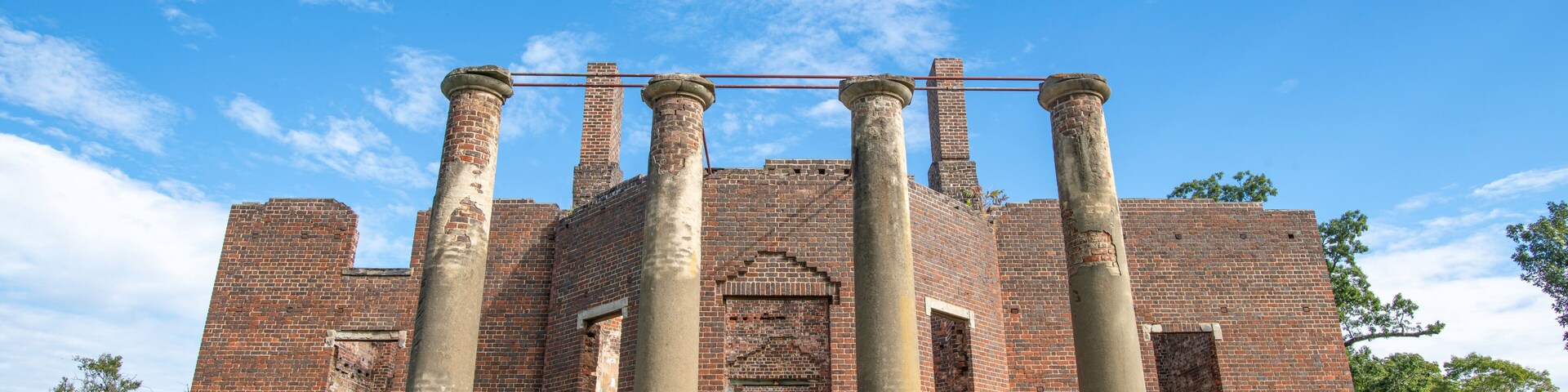 Un edificio histórico de ladrillo con grandes columnas y una entrada central.