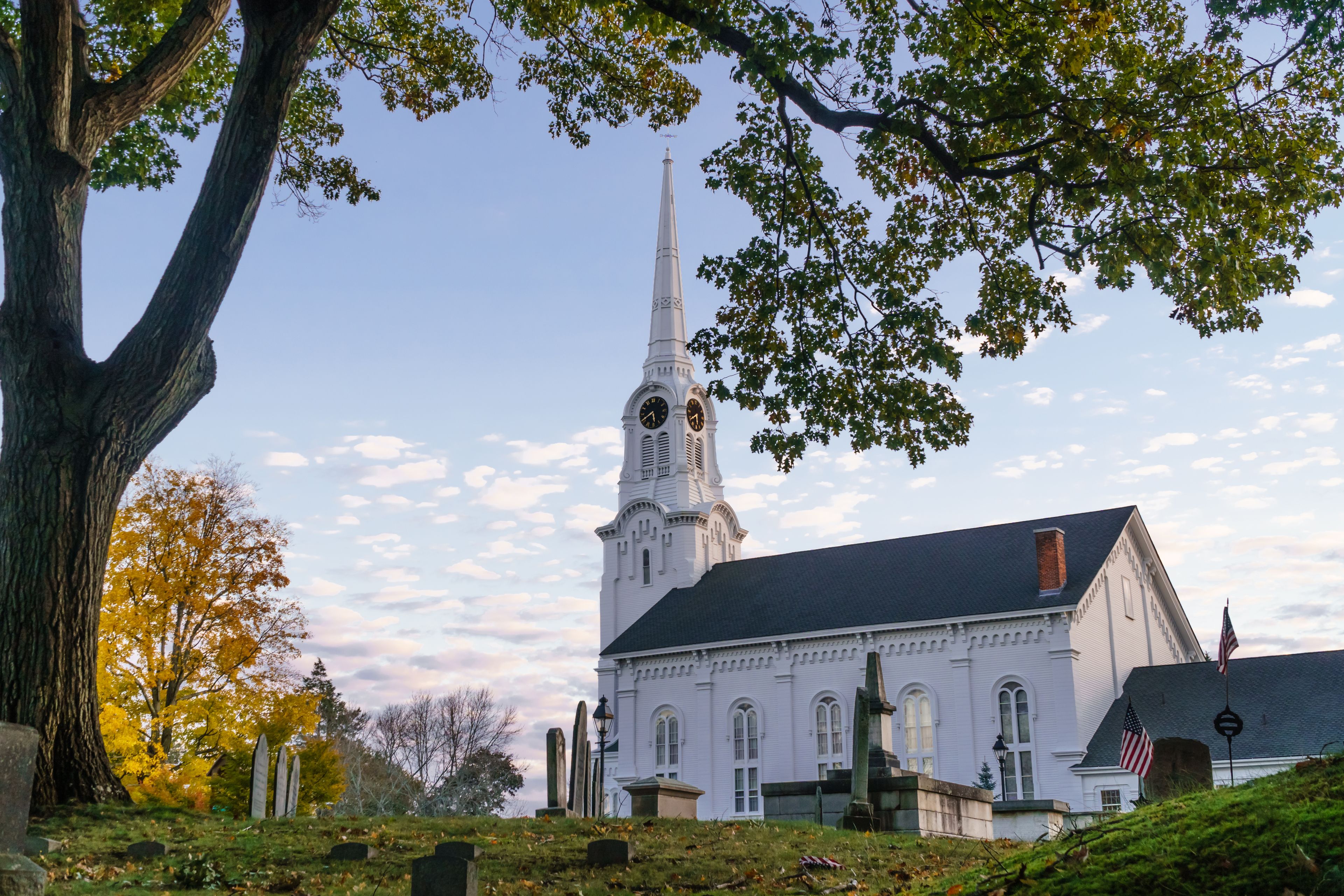 Andover, MA, US-October 22, 2024: South Church in Andover, Massachusetts - a classic white church with blue sky and old cemetery in foreground.