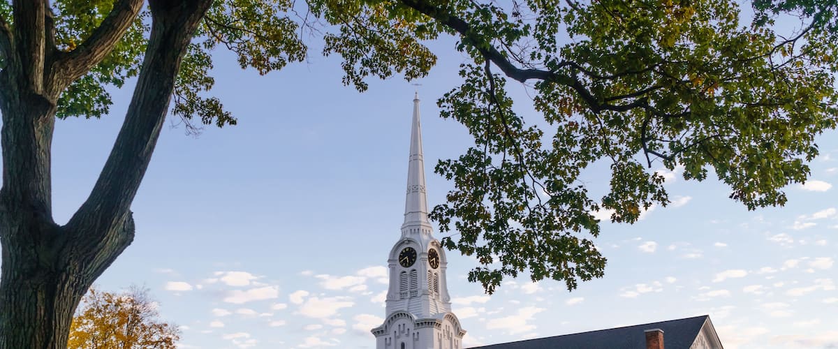 Andover, MA, US-October 22, 2024: South Church in Andover, Massachusetts - a classic white church with blue sky and old cemetery in foreground.