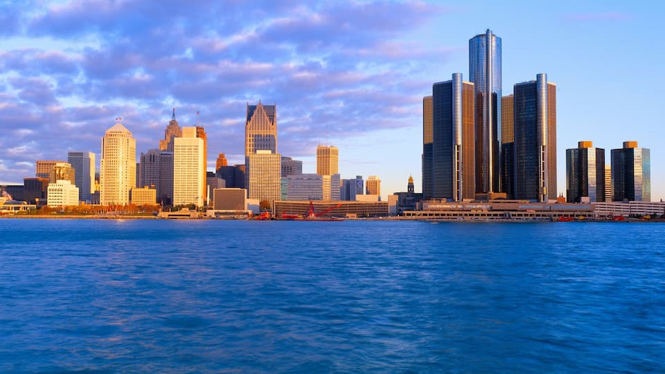 A city skyline with prominent skyscrapers and a body of water in the foreground.