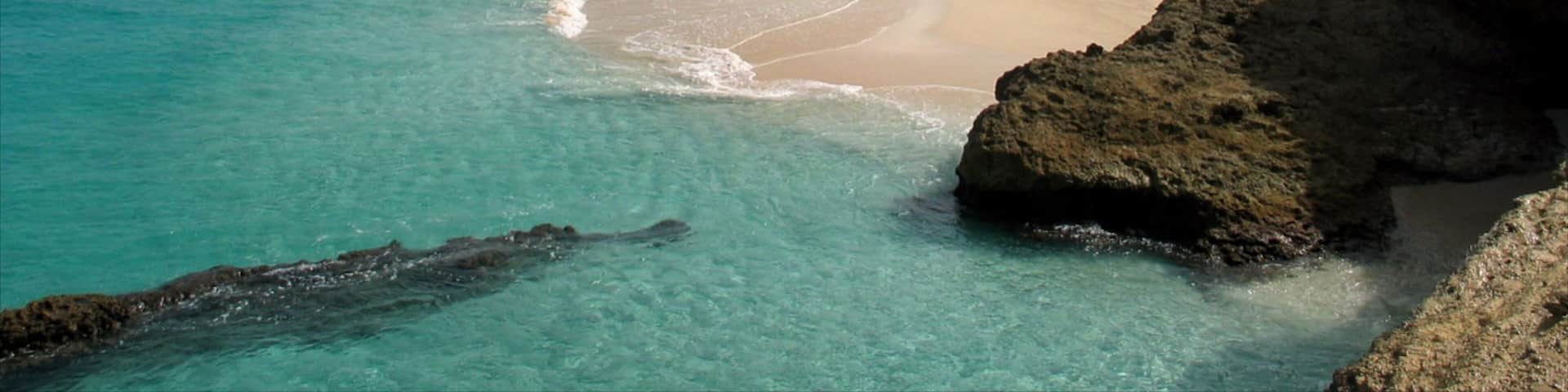 Anguila que incluye costa rocosa, vista panorámica y una playa de arena
