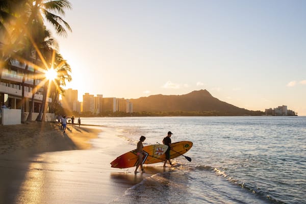 Waikiki Beach featuring a coastal town, kayaking or canoeing and a sunset