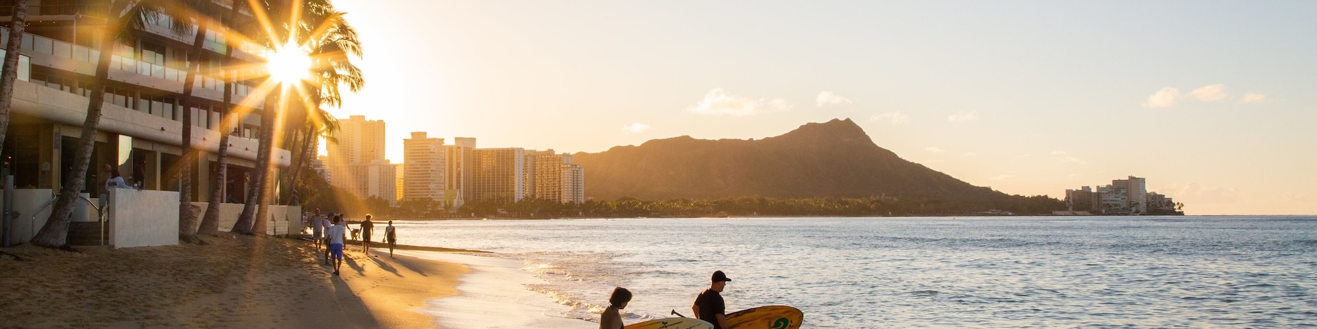 Waikiki Beach featuring a coastal town, kayaking or canoeing and a sunset