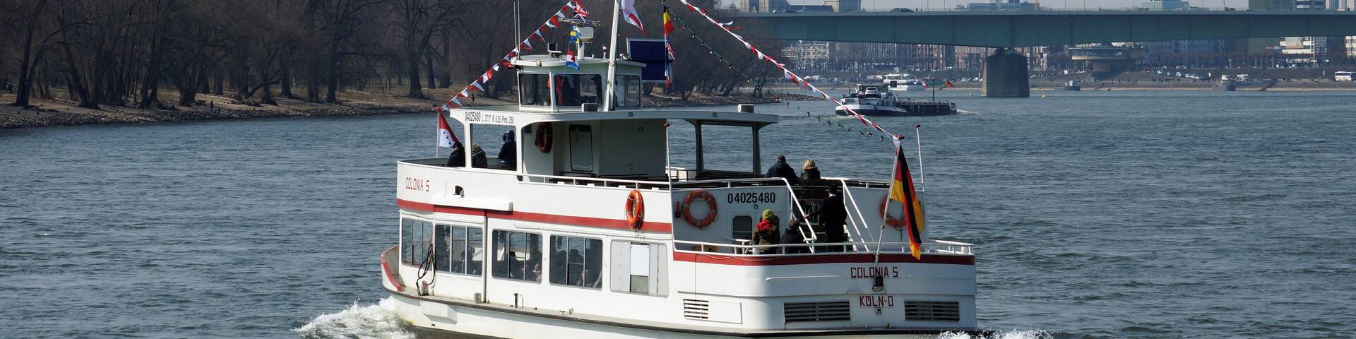 A white boat with red and white stripes on a river.