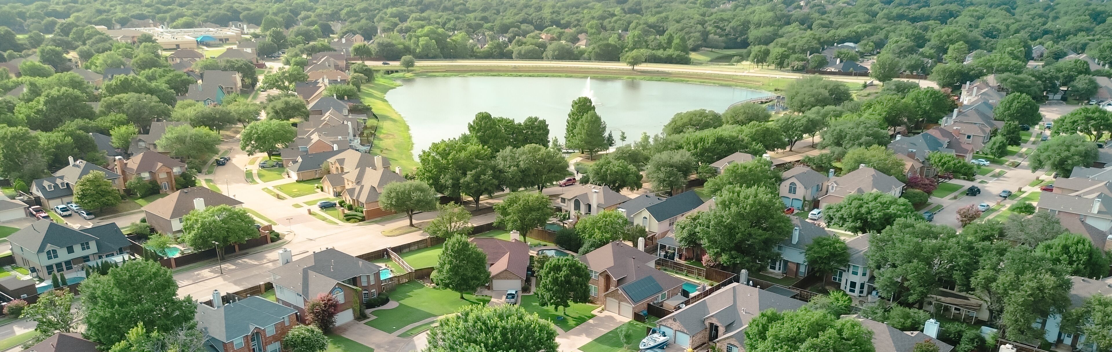 Panorama aerial view upscale waterfront residential properties suburbs Dallas Fort Worth metroplex, Rheudasil Park two-story homes, cul-de-sac streets, large backyards, swimming pools, trees