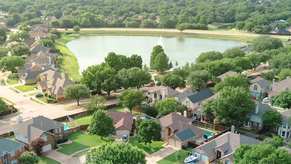 Panorama aerial view upscale waterfront residential properties suburbs Dallas Fort Worth metroplex, Rheudasil Park two-story homes, cul-de-sac streets, large backyards, swimming pools, trees