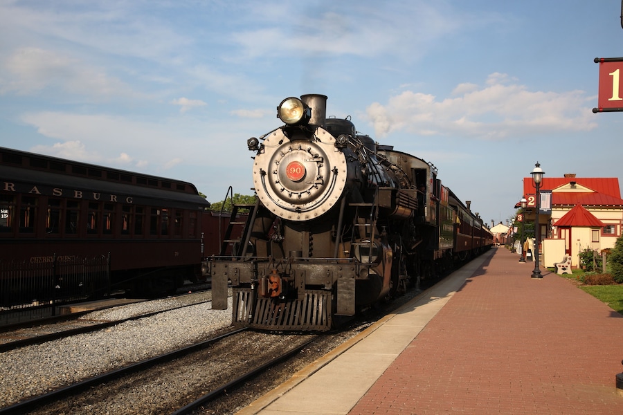 A smoke steam locomotive operated by the Strasburg Rail Road stops and awaits departure at the train station in Strasburg, Lancaster County, Pennsylvania.