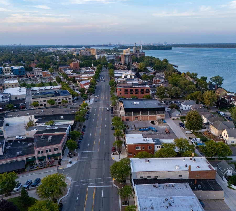 Aerial view of the city of Wyandotte, featuring urban streets, commercial buildings, residential areas, and the waterfront along the Detroit River in Wyandotte, Michigan, United States.