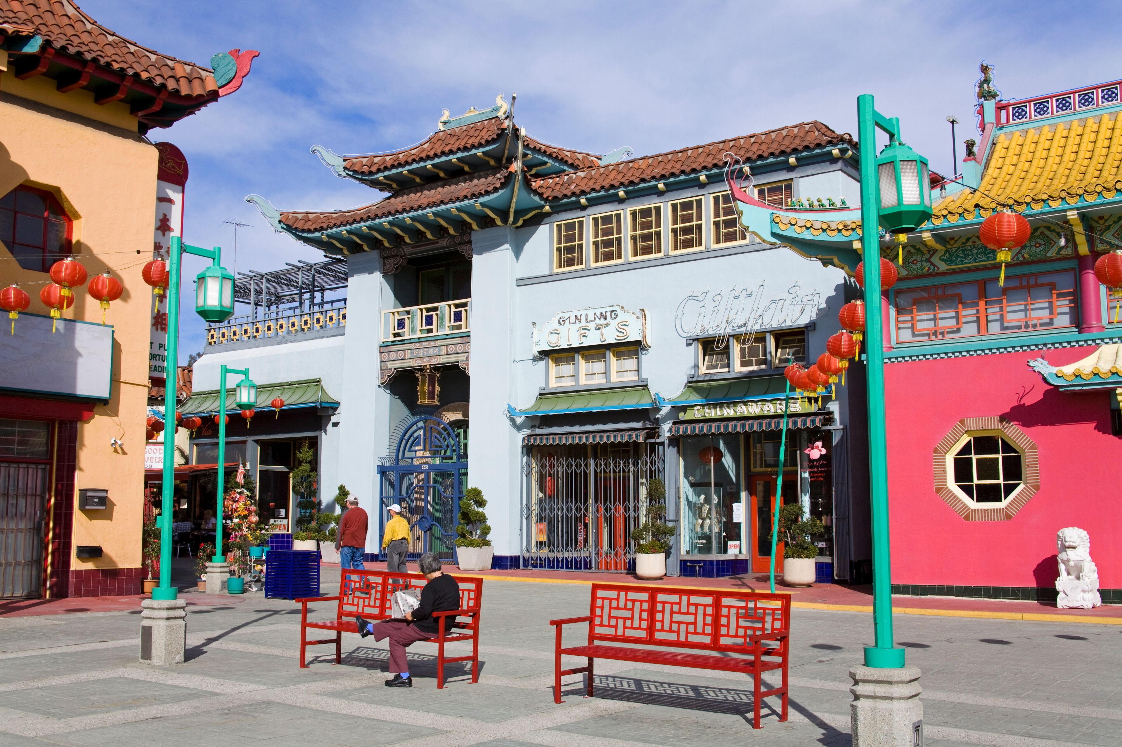 Um edifício tradicional chinês com uma placa que diz 'GUN LING GIFTS' e uma fachada colorida com telhado vermelho e amarelo.